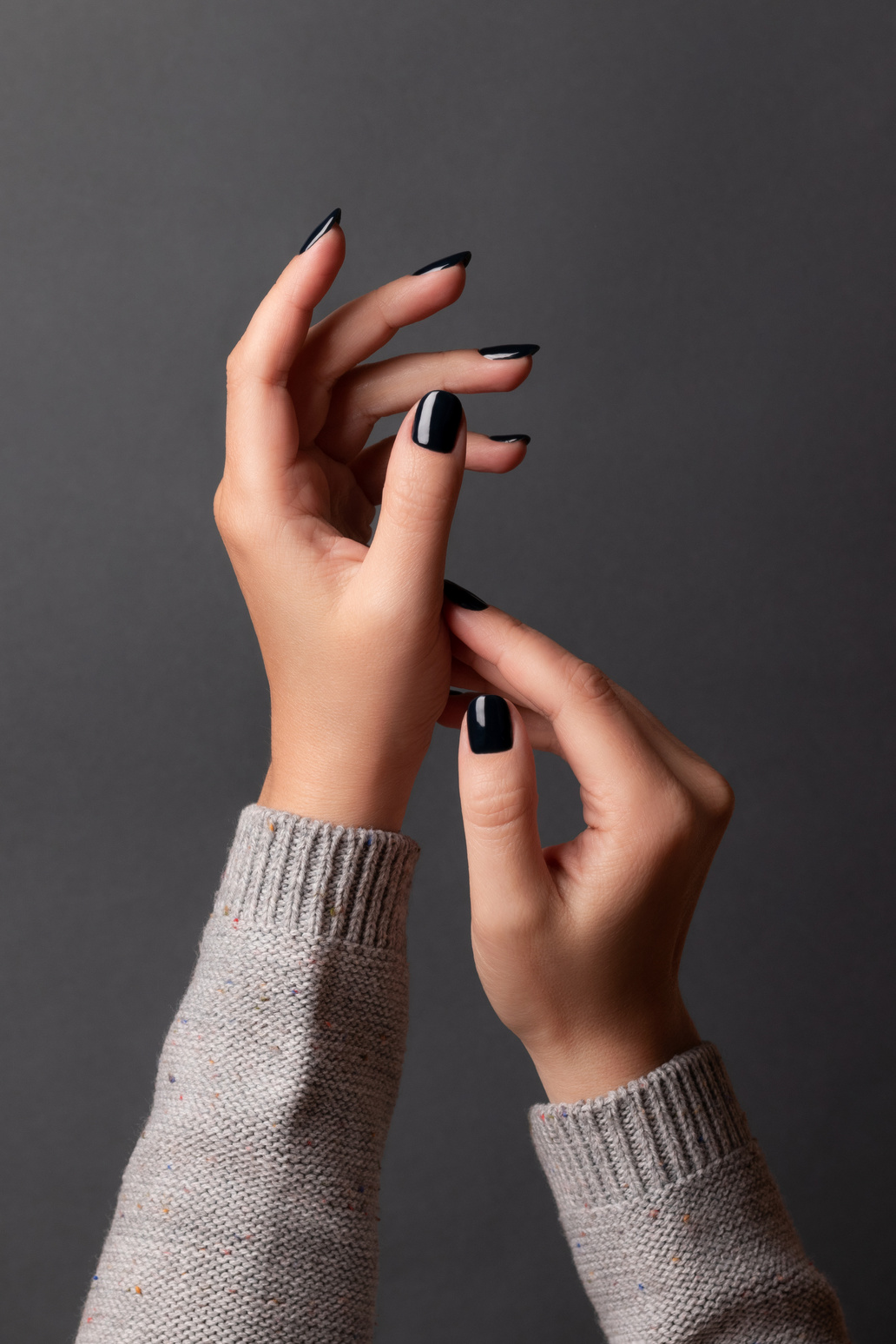Female Hands with Black Manicure Nails on Gray Background